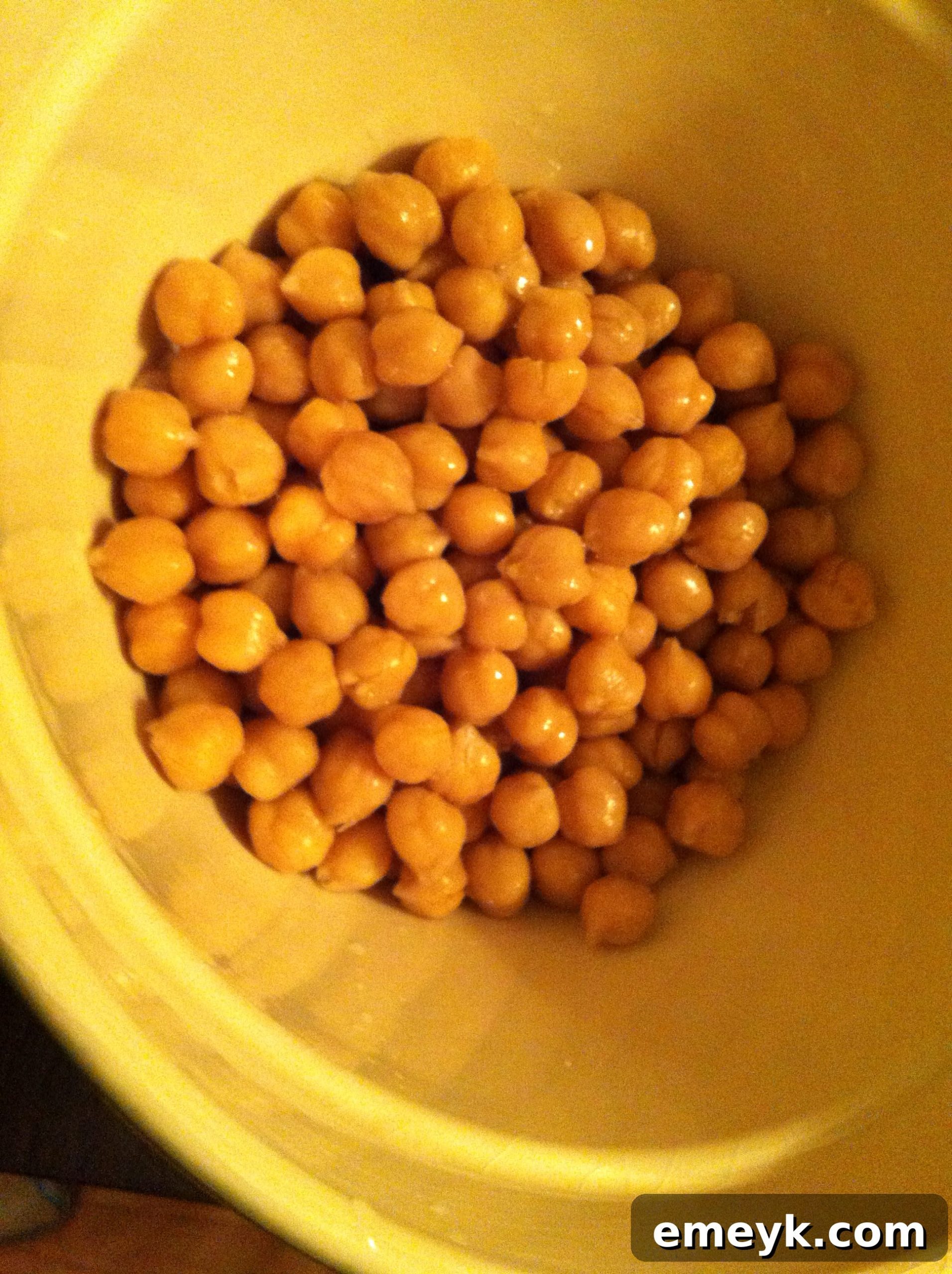 Freshly rinsed and drained chickpeas, ready for seasoning, resting in a large mixing bowl.