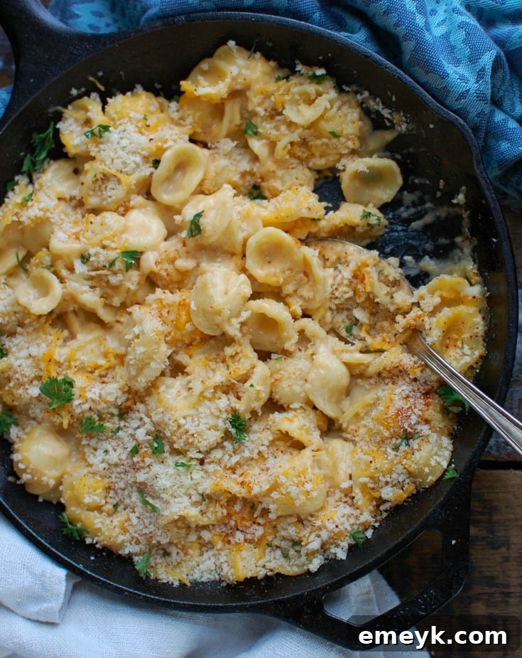 Baked Mac and Cheese with Panko Breadcrumbs, scooped with a spoon for serving.