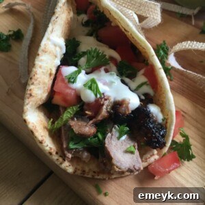 Mediterranean Steak Pita Wrap with Mint Yogurt Sauce on cutting board.