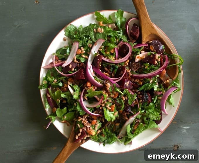 Hearty Farro Salad with Roasted Beets and Arugula 4 Overhead shot of a bowl of Farro Roasted Beet Arugula Salad with a fork, ready to be enjoyed.