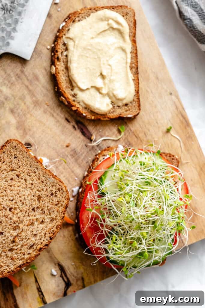 Fresh sprouts being added as the final layer to the sandwich filling.