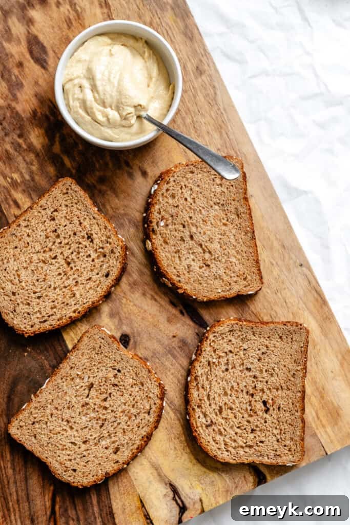 Four slices of bread ready for spreading, on a cutting board.