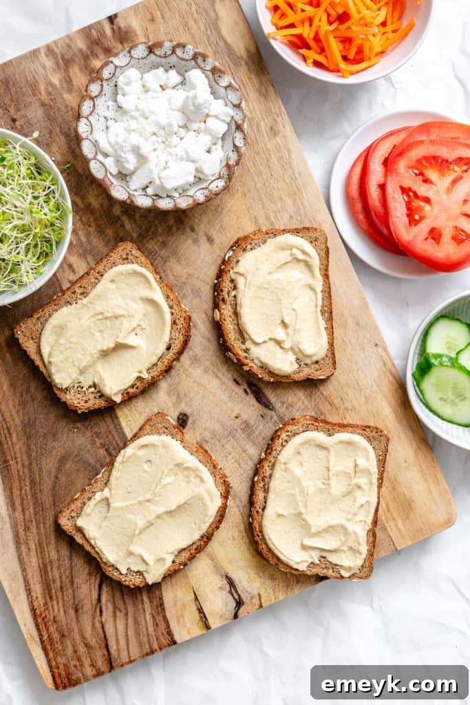 Hummus being spread evenly onto a slice of bread.