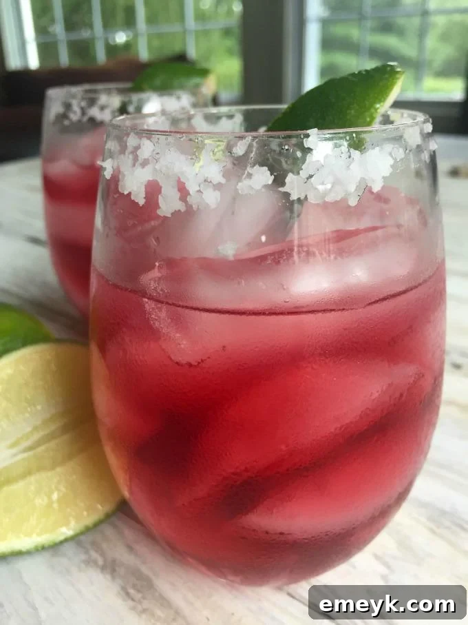 Ruby Pomegranate Margarita 4 Multiple Pomegranate Margaritas served in glasses with lime wedges, ready for a party.