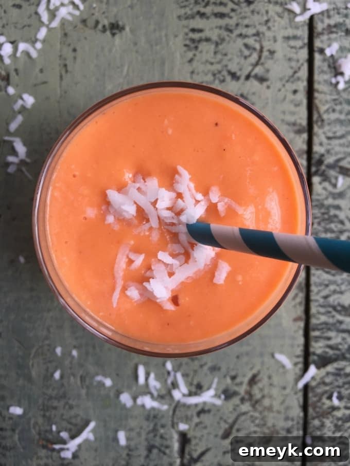 Golden Glow Smoothie 3 Two glasses of Coconut Carrot Smoothie on a wooden table
