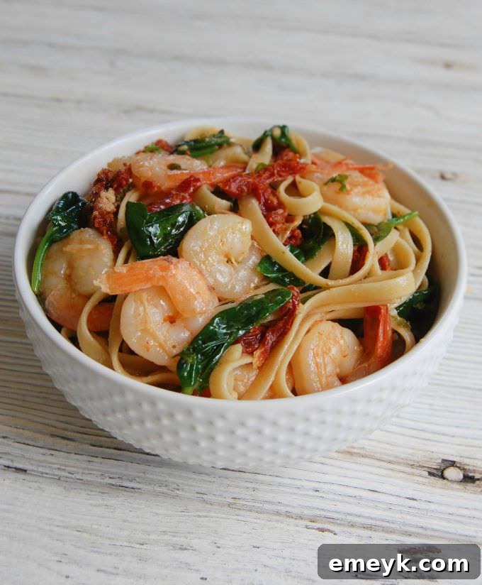 Easy Shrimp Scampi Recipe in a white bowl, garnished with fresh parsley and lemon slices.