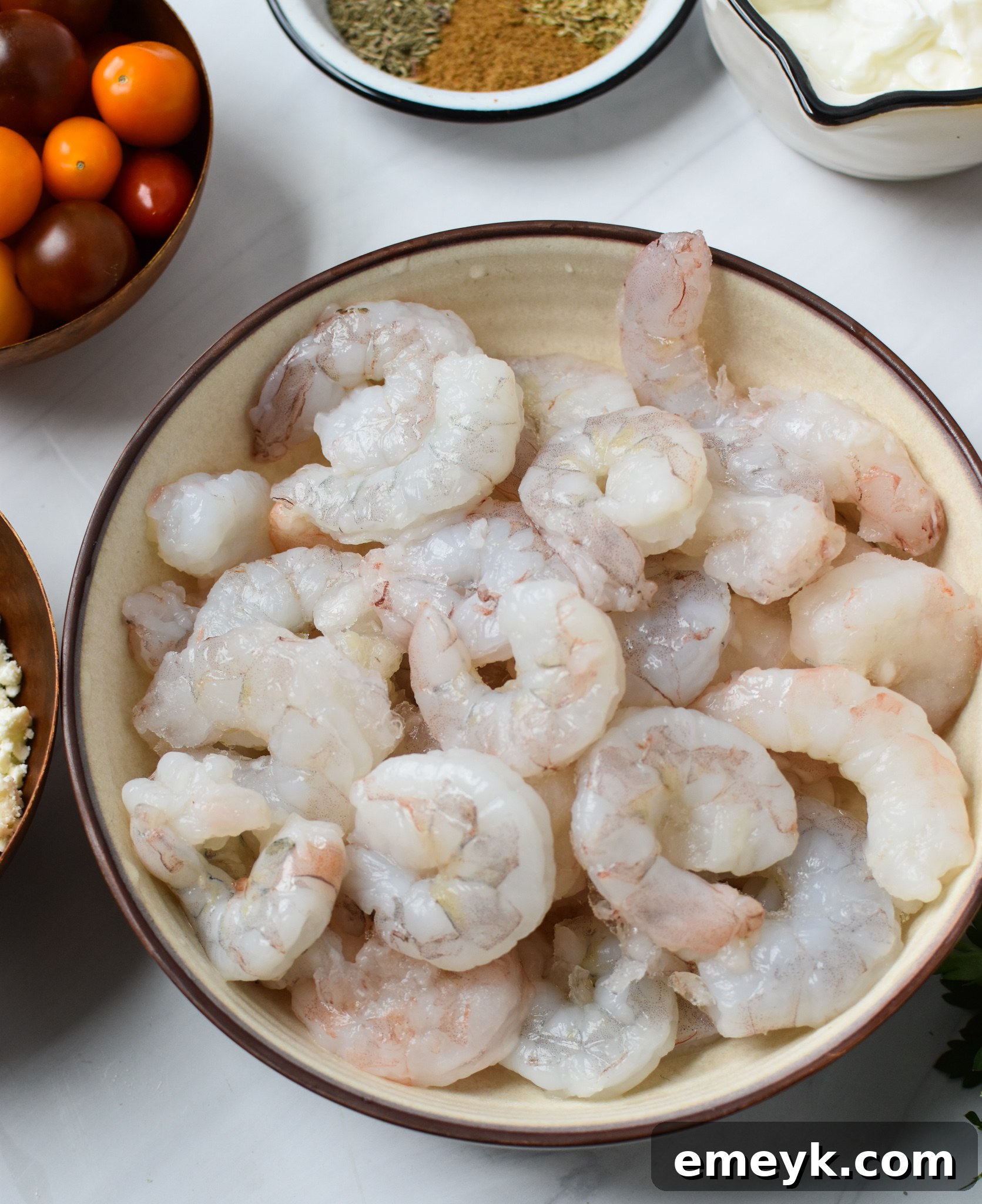 An image showing various Mediterranean-style grilled shrimp skewers and ingredients.