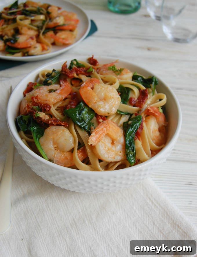 A close-up of Easy Shrimp Scampi Recipe with a linen napkin, showing the rich texture and garnishes.