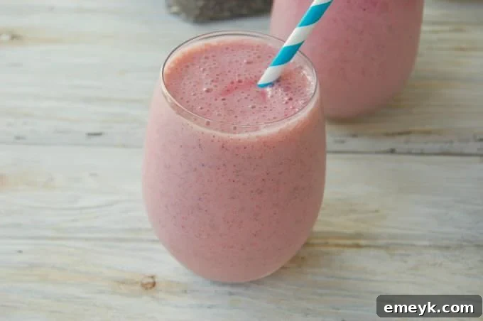 Close-up of a Strawberry Banana Chia Smoothie with a straw, showcasing its creamy texture.