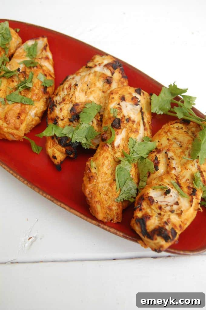 Plated Tandoori Grilled Chicken garnished with fresh cilantro and lime, ready to serve.
