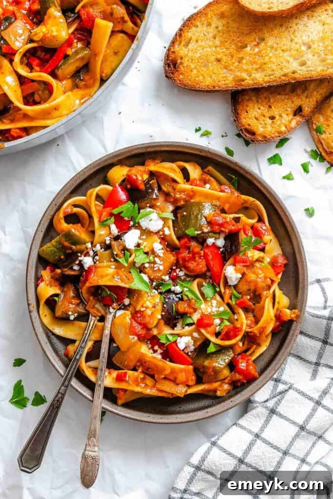 A bowl of Ratatouille Pappardelle garnished with feta and parsley, ready to be enjoyed.