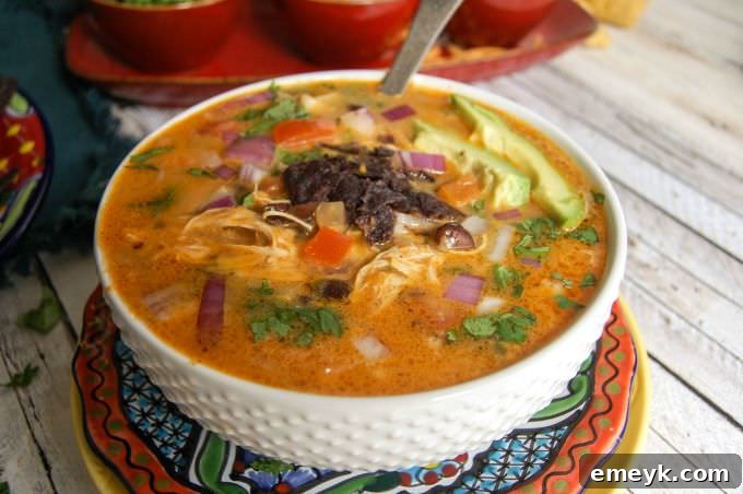 A close-up view of the Slow Cooker Mexican Cheesy Chicken Soup gently simmering in the pot, showcasing the rich texture and melted cheese.