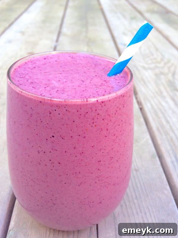 Vibrant Blueberry Mango Lime Smoothie in a glass with a lime slice