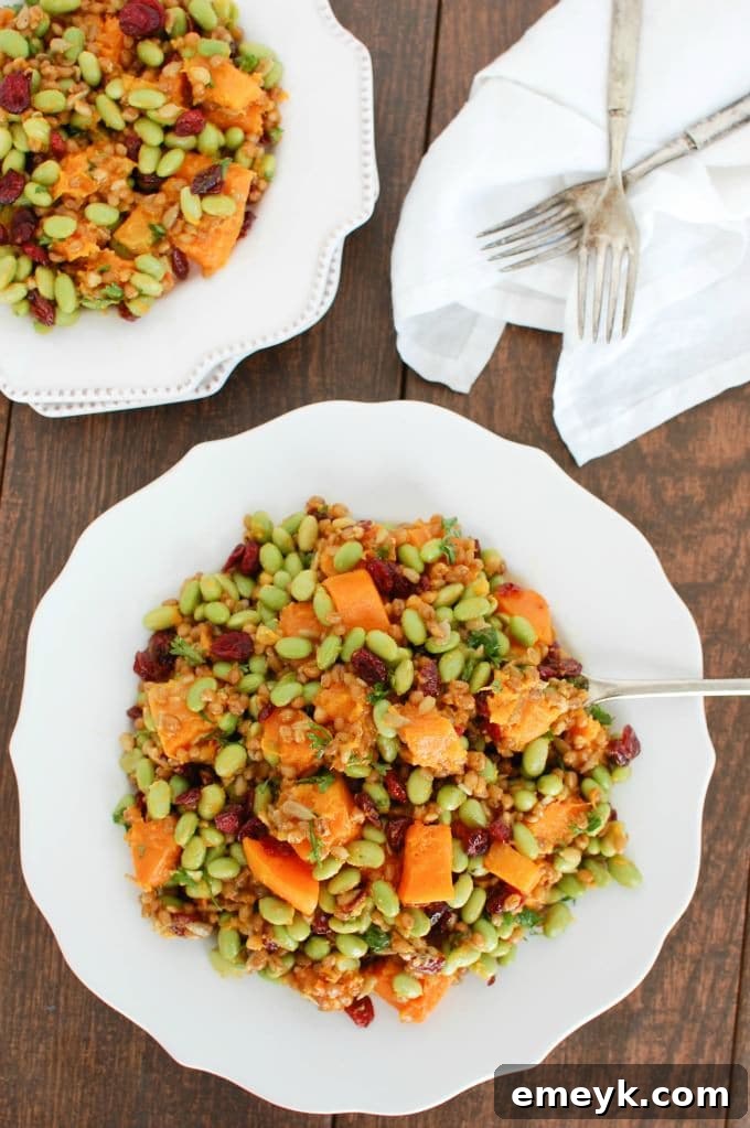 Healthy and nutritious Wheat Berries with Butternut Squash, Edamame, and Cranberries, garnished with fresh herbs and a hint of orange zest
