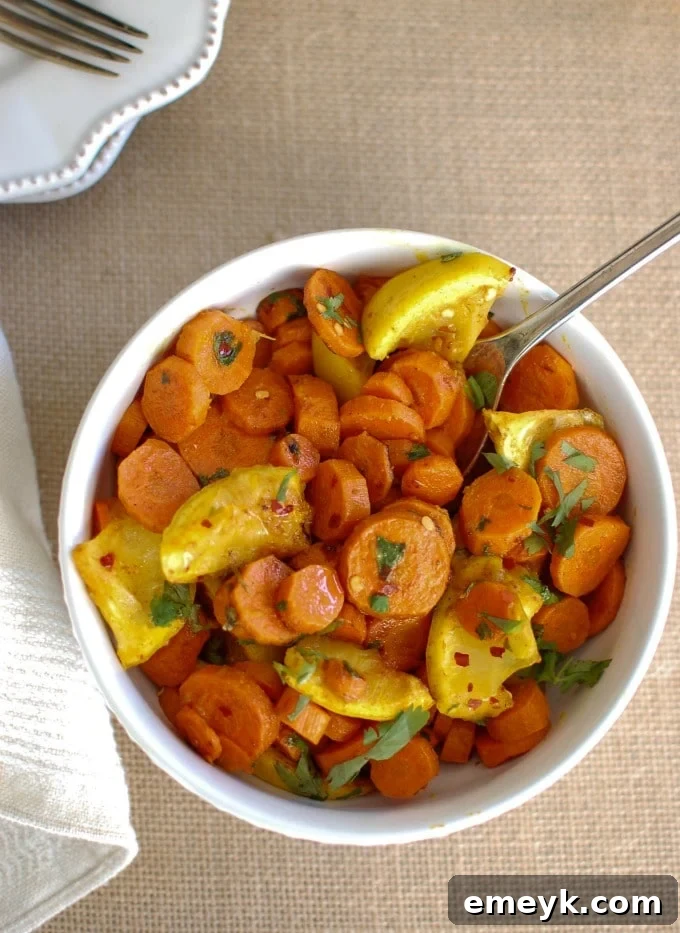 Vibrant Moroccan Roasted Carrots on a serving platter, garnished with fresh cilantro and lemon wedges
