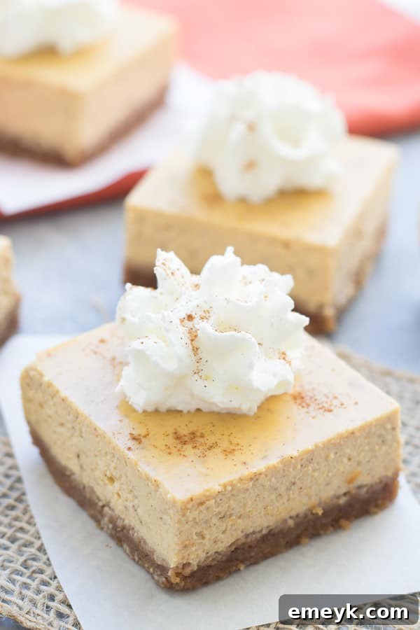 Irresistible Thanksgiving Treats 14 Pumpkin Greek yogurt cheesecake bars with a graham cracker crust and a creamy topping, sliced into squares.
