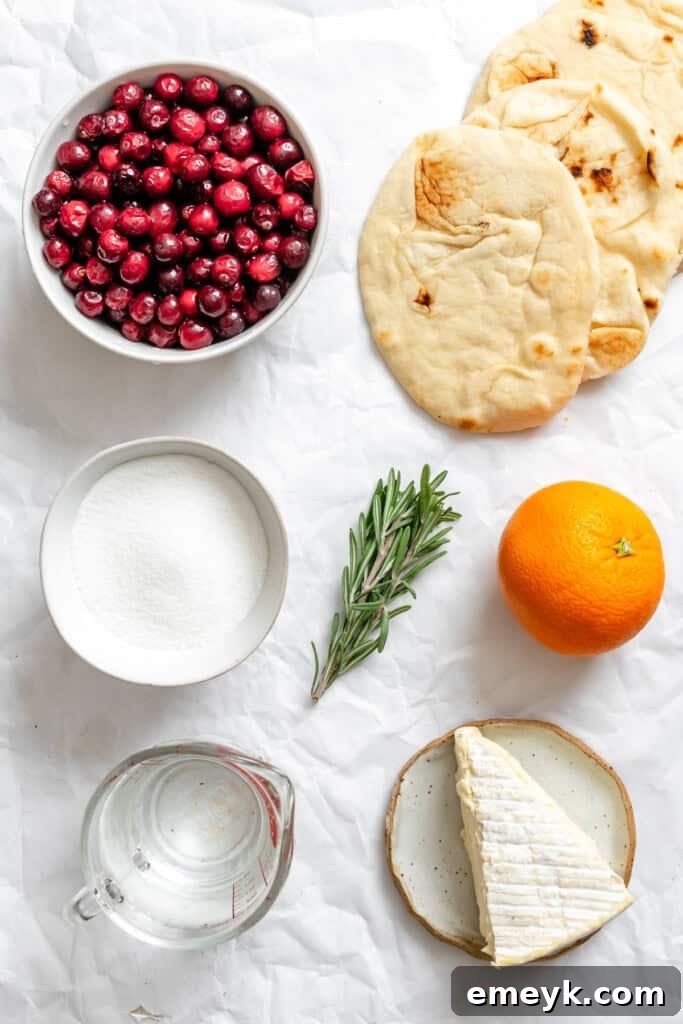 Warm Brie Cranberry Naan Bread recipe ingredients including cranberries, orange, brie, and rosemary