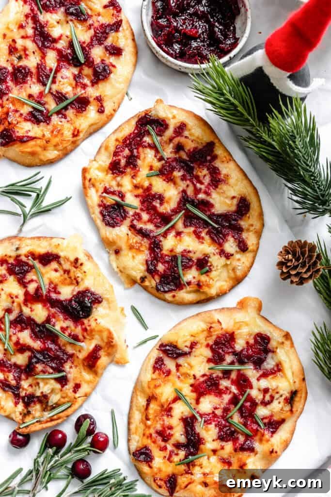 Warm Brie Cranberry Naan Bread garnished generously with fresh rosemary