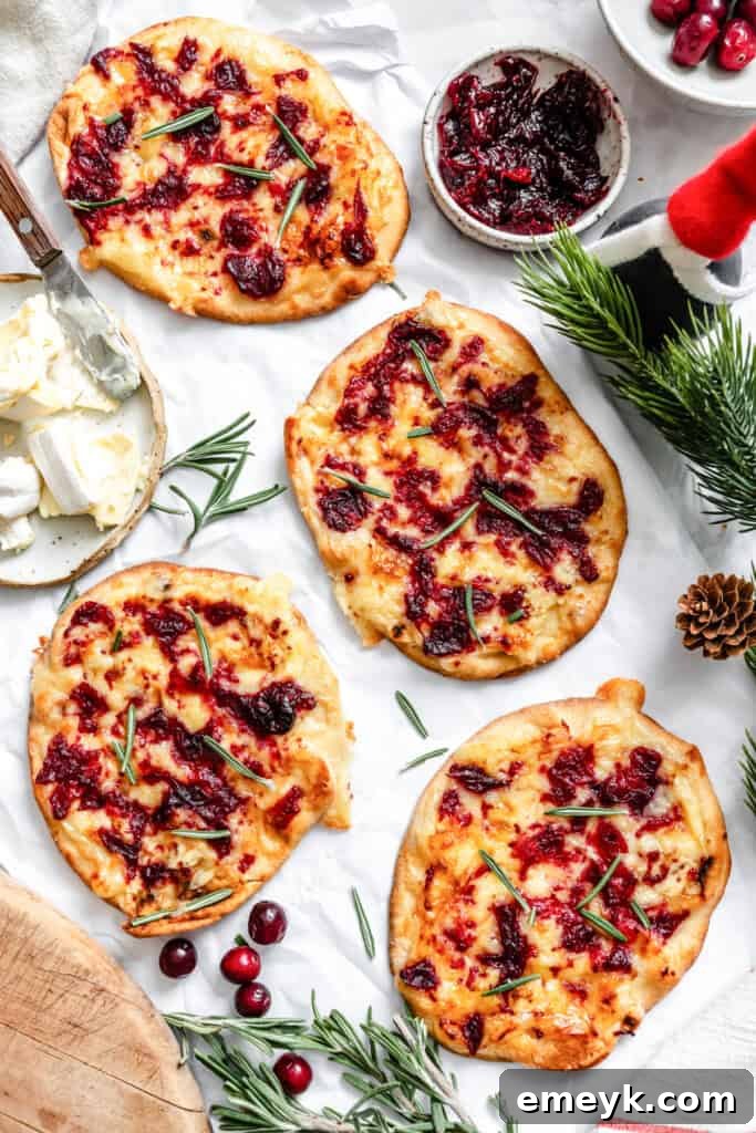 Warm Brie Cranberry Naan Bread on a white surface, cut into slices for serving