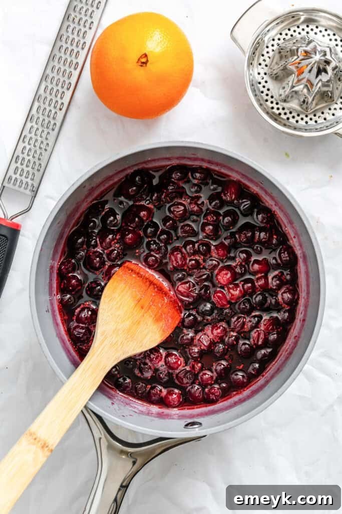 Cranberries, sugar, and water simmering in a pot for the sauce