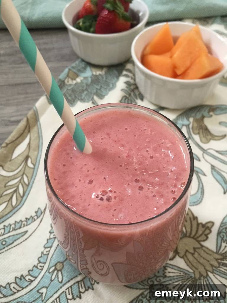 My 15 Standout Recipes from 2015 6 A vibrant pink Strawberry Cantaloupe Smoothie in a glass with a straw, garnished with fresh strawberries.