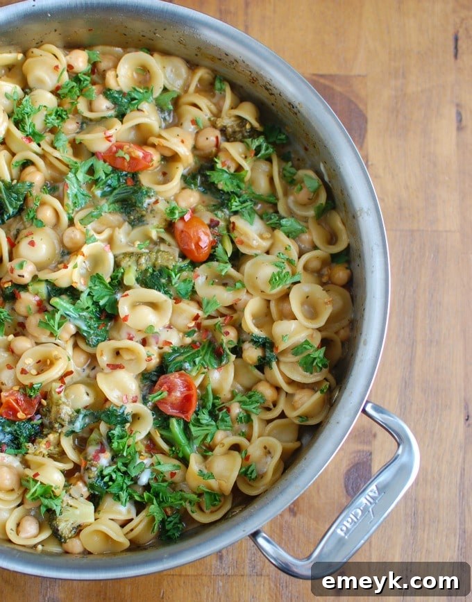 One Pot Chickpea Kale Pasta Recipe in a pan with cherry tomatoes.
