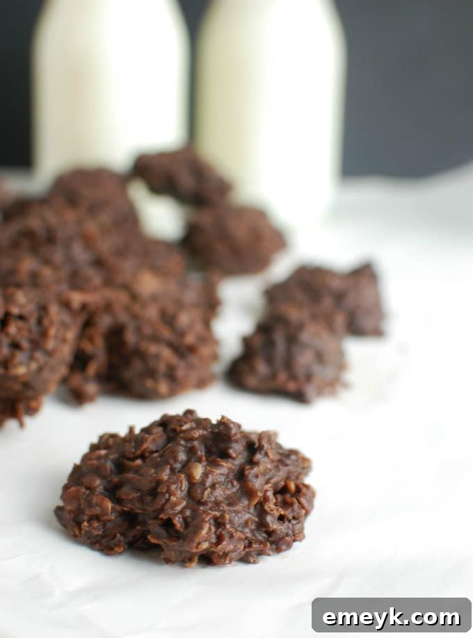 Delightful No Bake Cookies on a white surface, perfectly paired with a glass of milk, inviting a sweet treat experience.