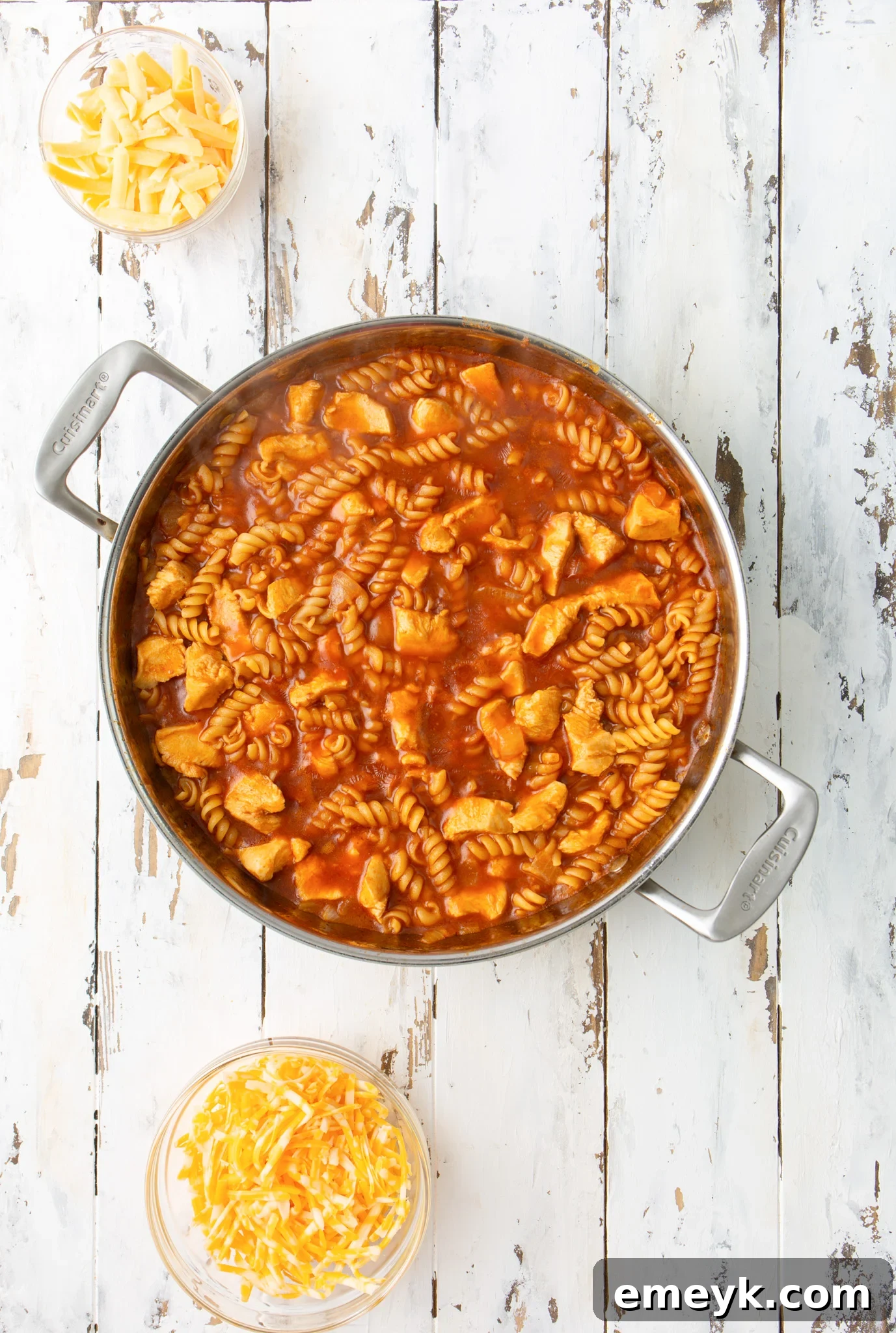 One Pot Chicken Enchilada Pasta simmering in a skillet, with noodles absorbing the rich red sauce.