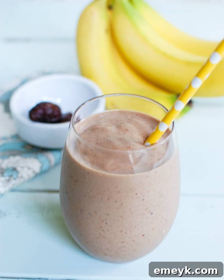 Banana Date Smoothie served in a glass with a straw, ready to enjoy.