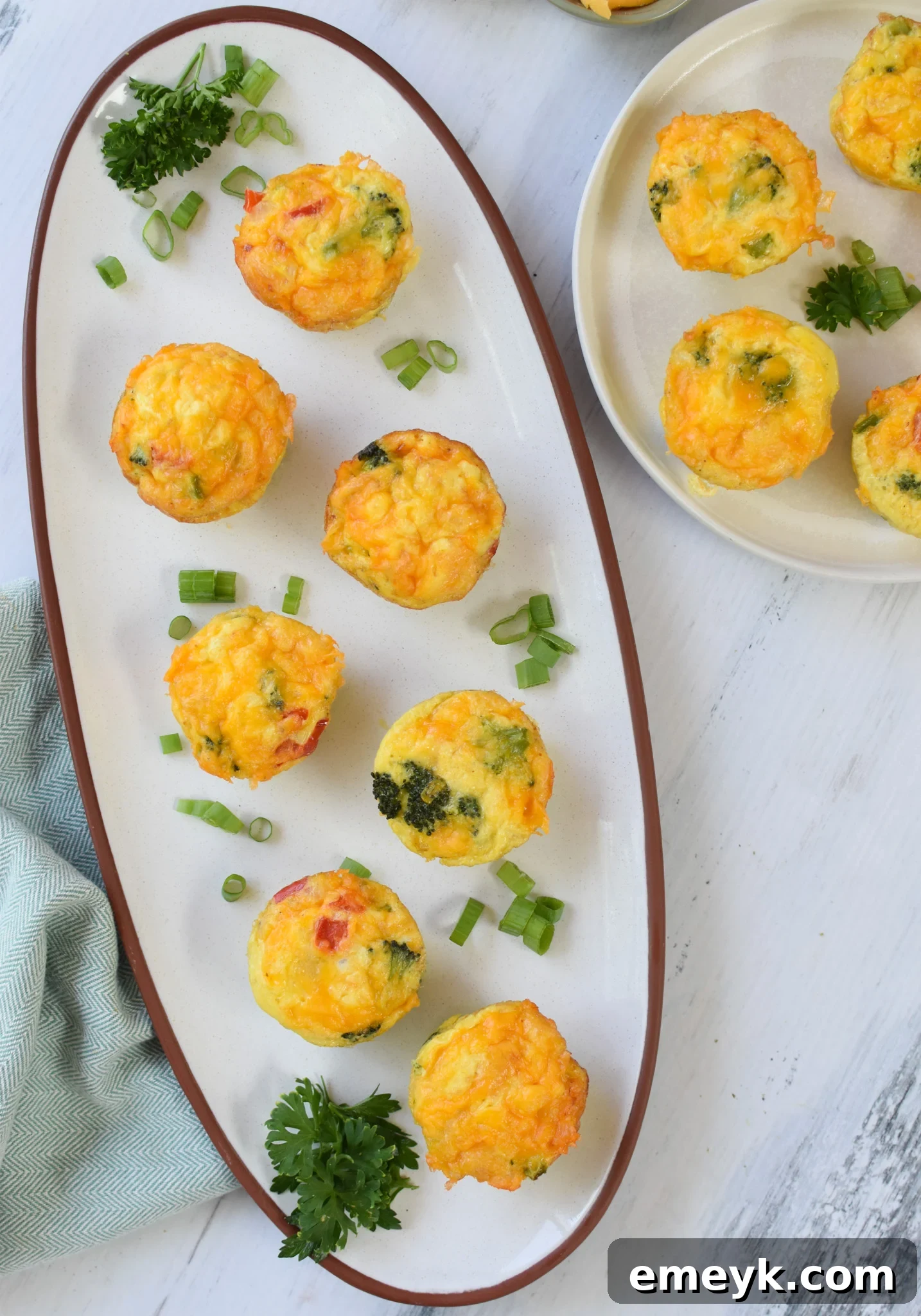 Savory Broccoli Cheddar Bites 12 Broccoli Cheddar Cups arranged on a white plate with a side of fresh berries.