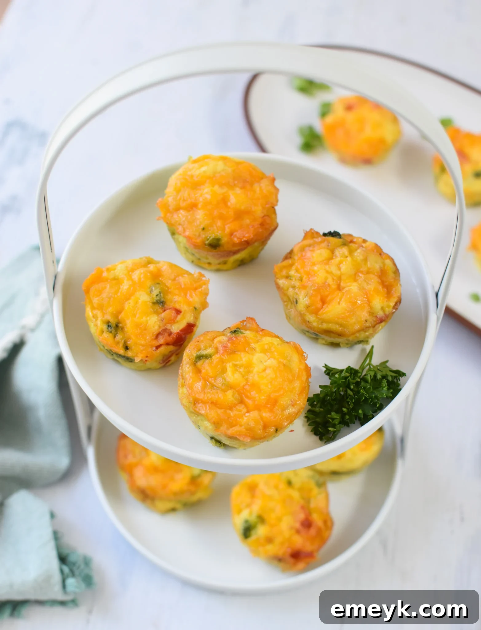 Savory Broccoli Cheddar Bites 6 Close-up of baked Broccoli Cheddar Cups on a white plate, ready to be served.