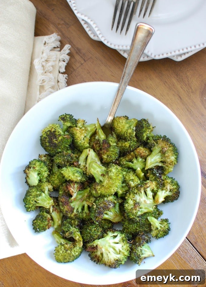 A fork piercing a piece of roasted broccoli, ready to be enjoyed.