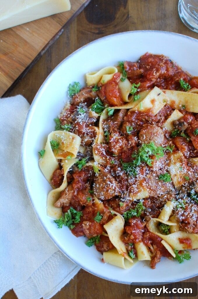 Rich Slow Cooker Turkey Sausage Bolognese Sauce over pasta, garnished with fresh herbs, ready to be served