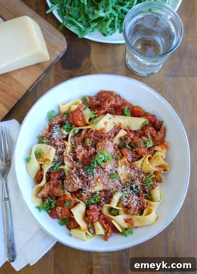 Serving of Slow Cooker Turkey Sausage Bolognese with fresh Parmesan and basil