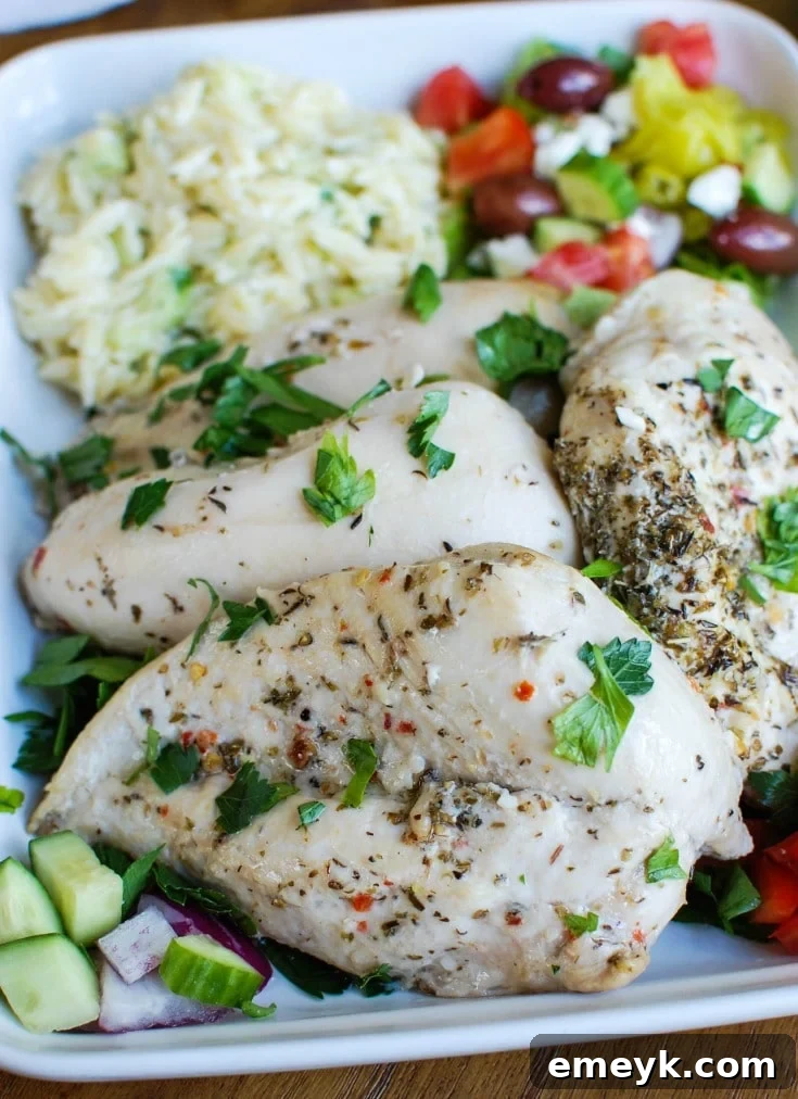 Greek Chicken with Tzatziki Orzo Salad in a big white dish, showcasing the vibrant colors of the Mediterranean ingredients.