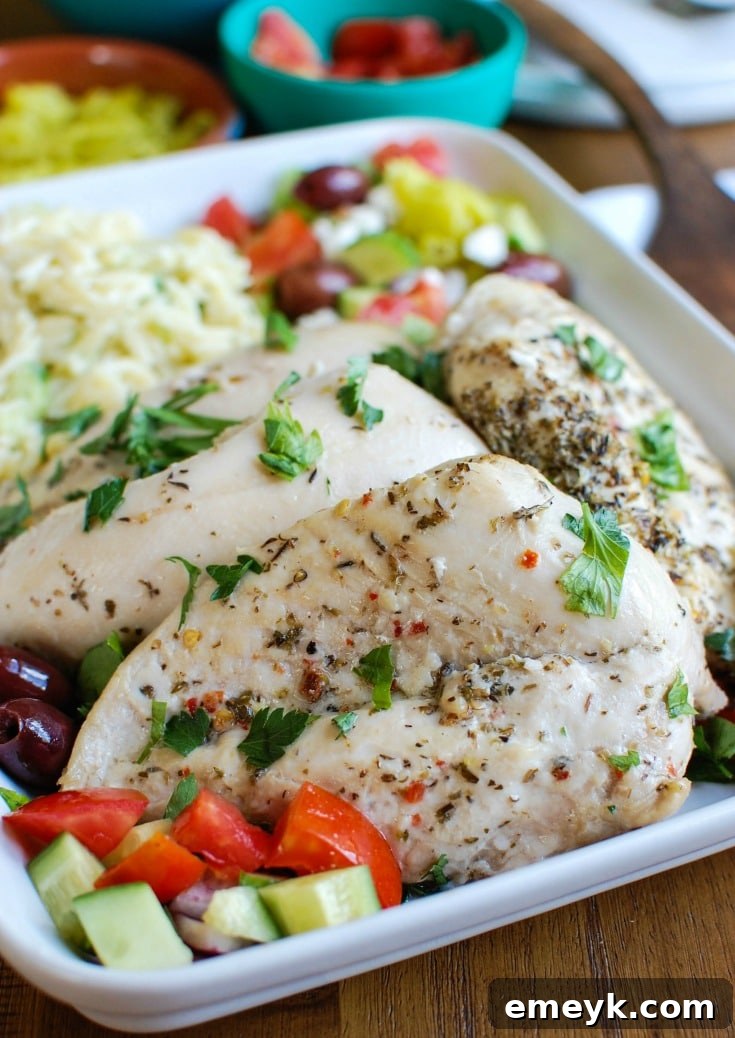 Greek Chicken with Tzatziki Orzo Salad garnished with Kalamata olives, close-up shot emphasizing texture and freshness.