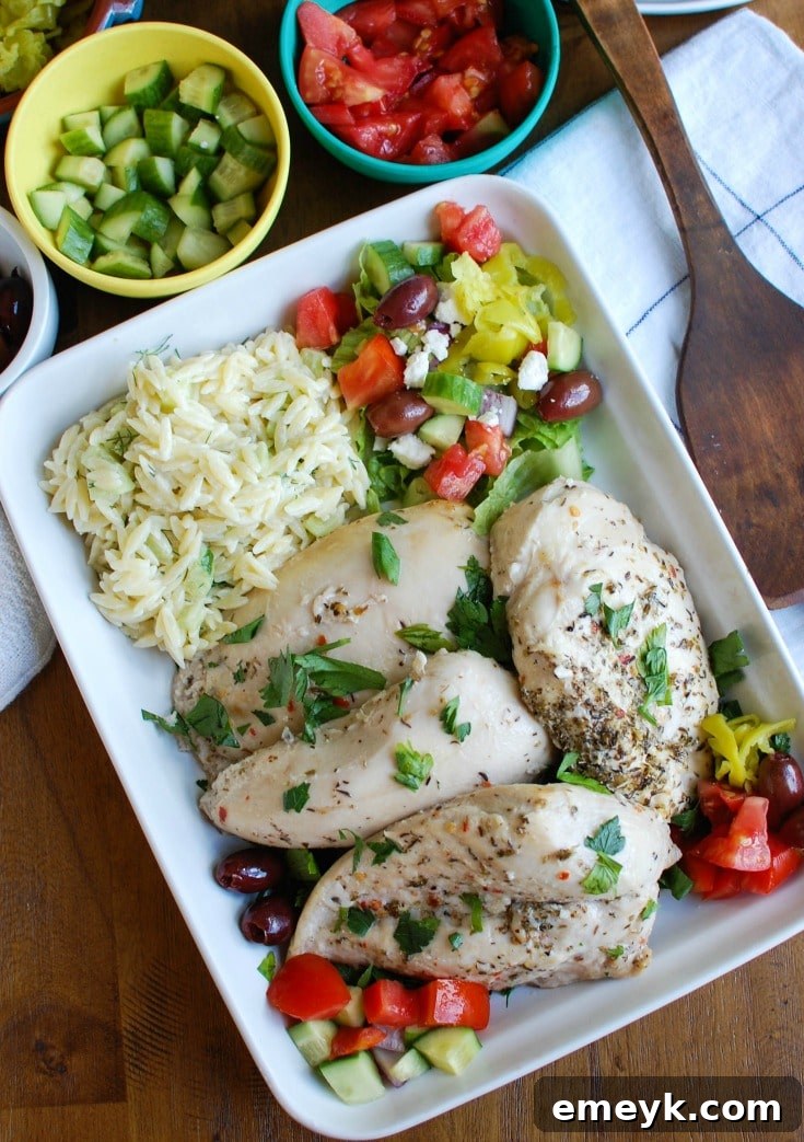 Greek Chicken with Tzatziki Orzo Salad on a white plate, close up of the orzo salad component with fresh herbs.