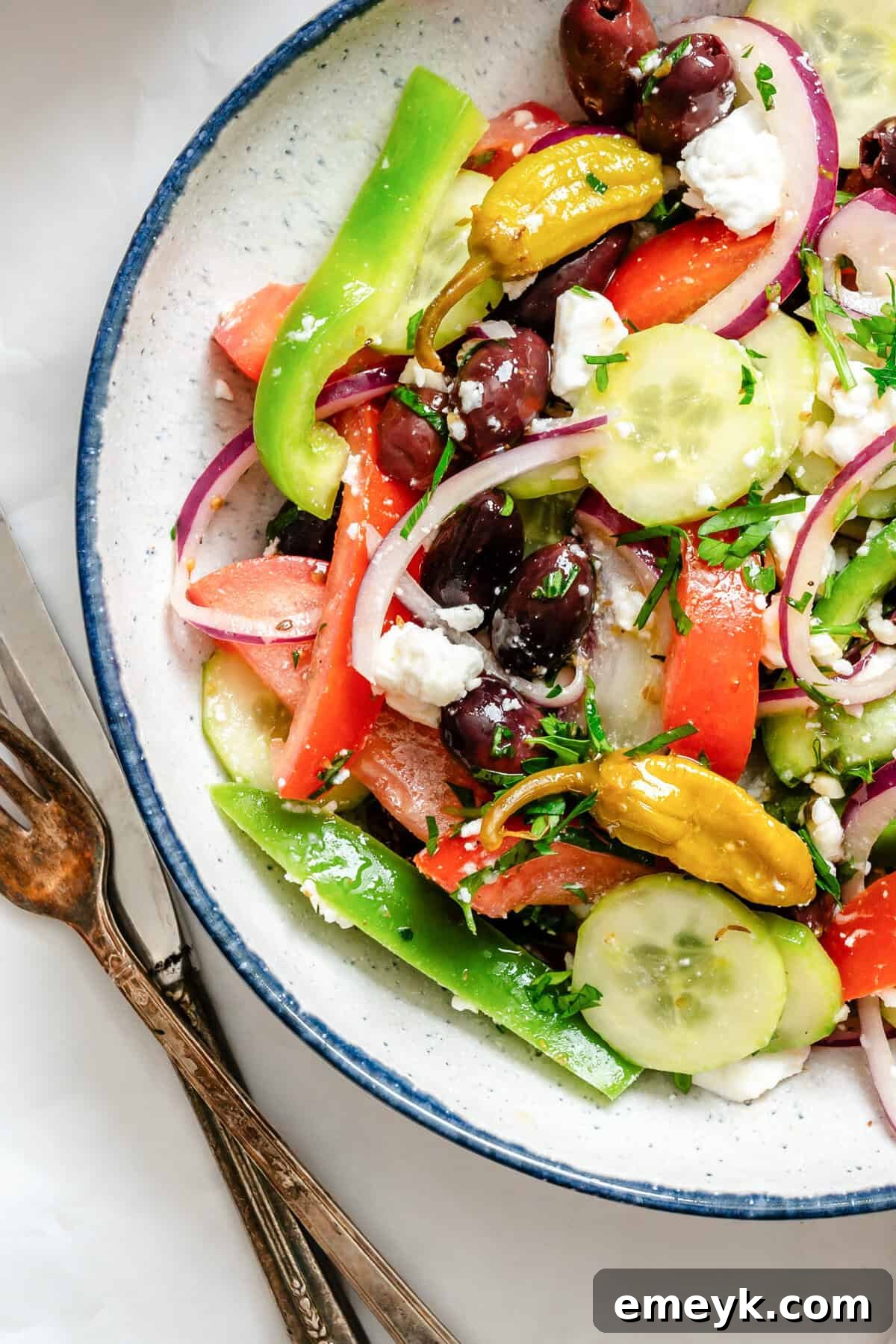 Close-up shot of Greek Village Salad in a bowl, showcasing the textures of feta, olives, and fresh vegetables.