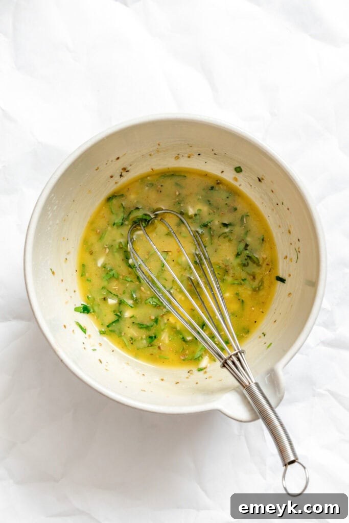 The perfectly mixed Greek Village Salad dressing in a bowl, showing the emulsified texture.