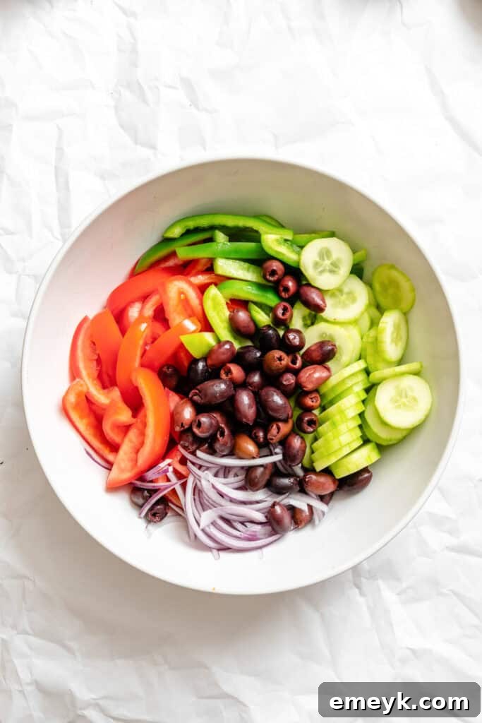 Freshly chopped Greek Village Salad vegetables in a bowl, before adding dressing or feta.
