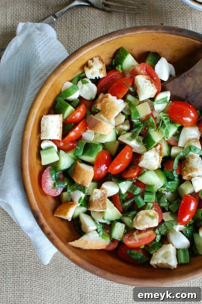 Vibrant Caprese Panzanella salad with fresh tomatoes, creamy mozzarella, fragrant basil, and golden toasted bread cubes.