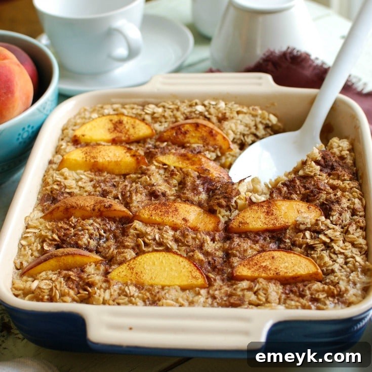 A serving of Peaches and Cream Baked Oatmeal, topped with a drizzle of maple syrup and a sprinkle of cinnamon, ready to be enjoyed.