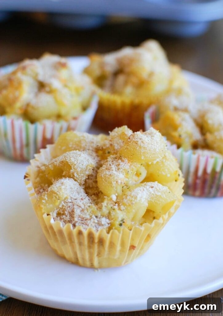 Mac and Cheese Muffins baking in a muffin tin, golden and bubbling