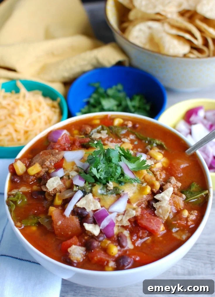 Close-up of Slow Cooker Turkey Kale Chili, ready to serve with fresh garnishes.