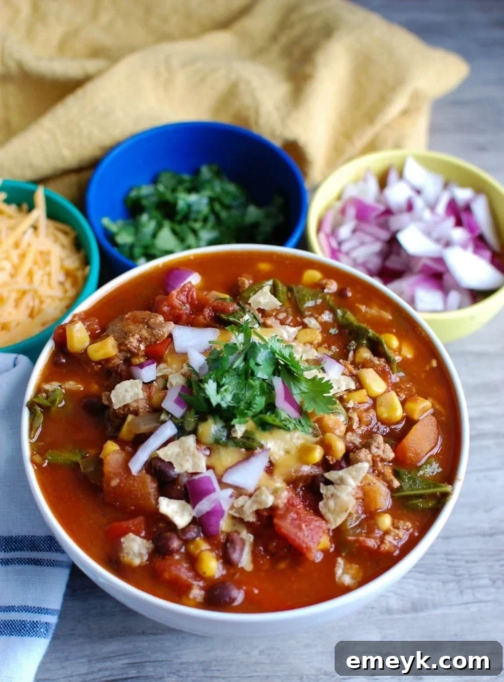 A bowl of Slow Cooker Turkey Kale Chili garnished with cilantro and sour cream.