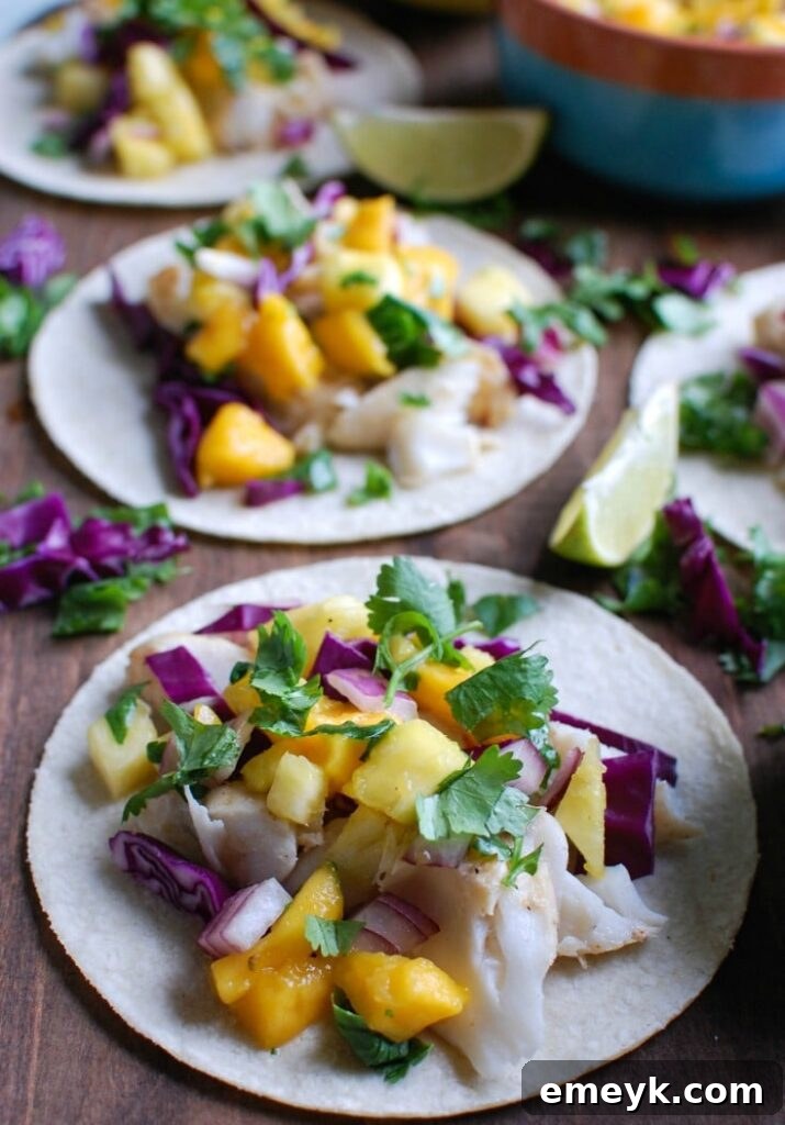 Grilled Fish Tacos with Tropical Salsa on a rustic cutting board, garnished with fresh cilantro and lime wedges