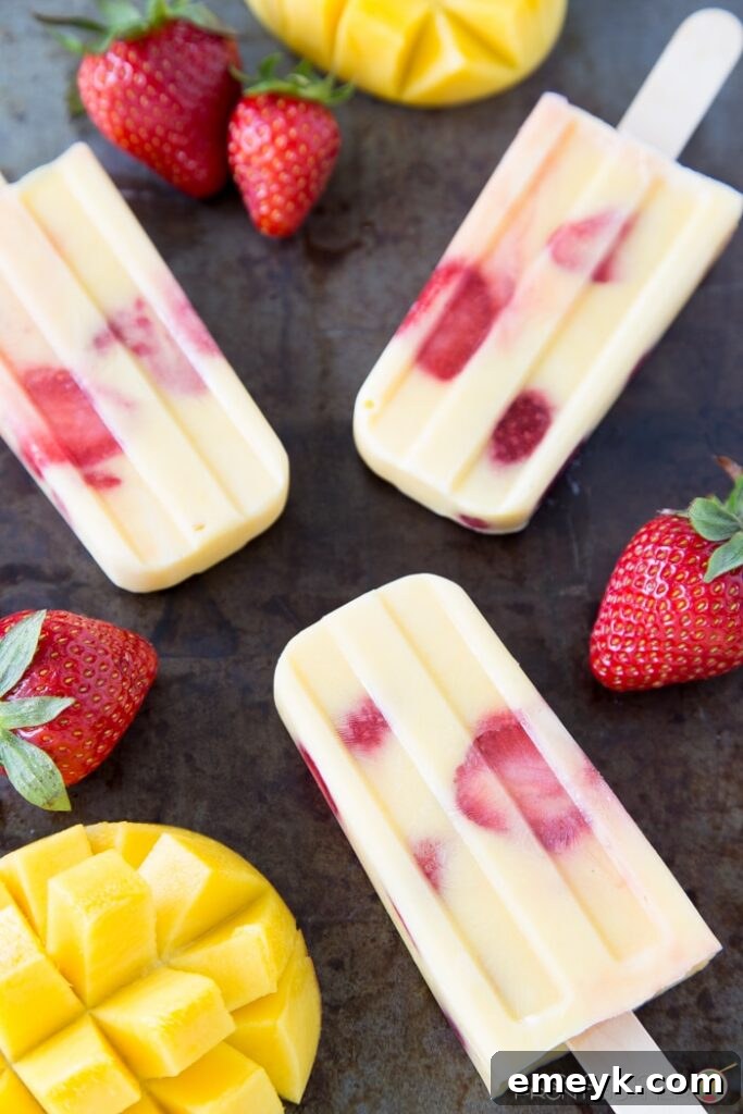 Colorful Mango Strawberry Yogurt Popsicles, a healthy and creamy fruit swirl for a sweet treat.
