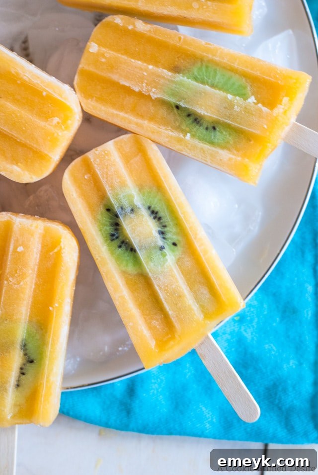 Tangy Mango Kiwi Lemonade Popsicles, a vibrant and refreshing tropical fruit blend with a zesty kick.