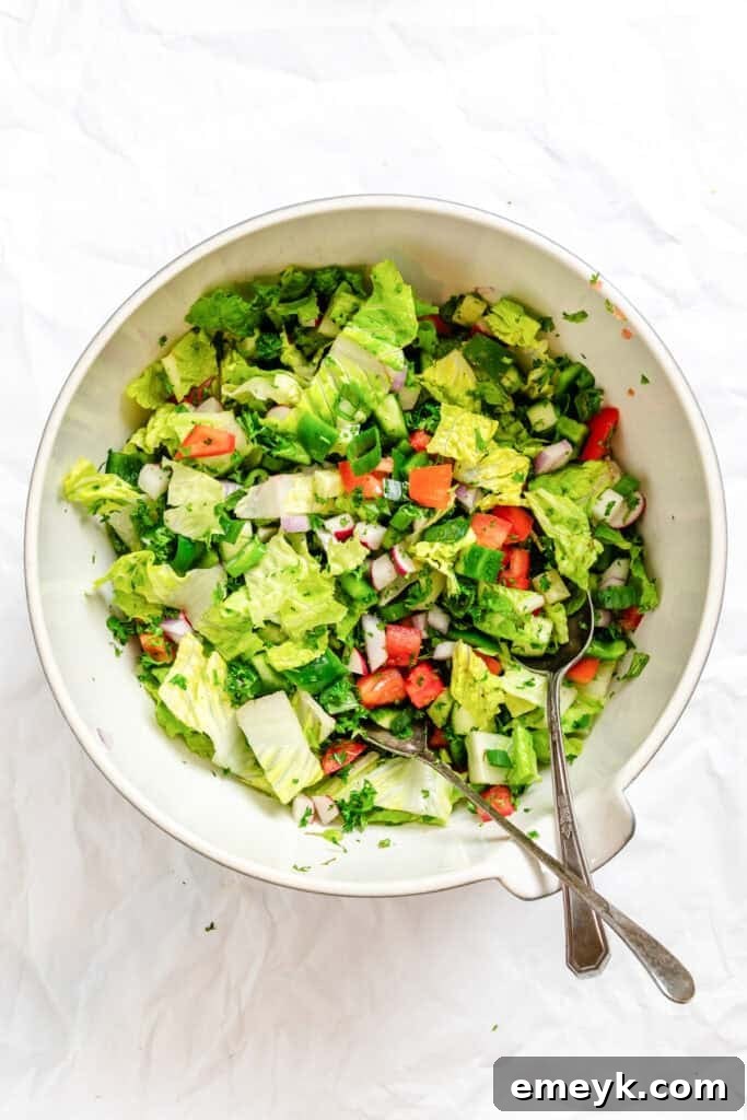 Fattoush Salad with tongs in a bowl