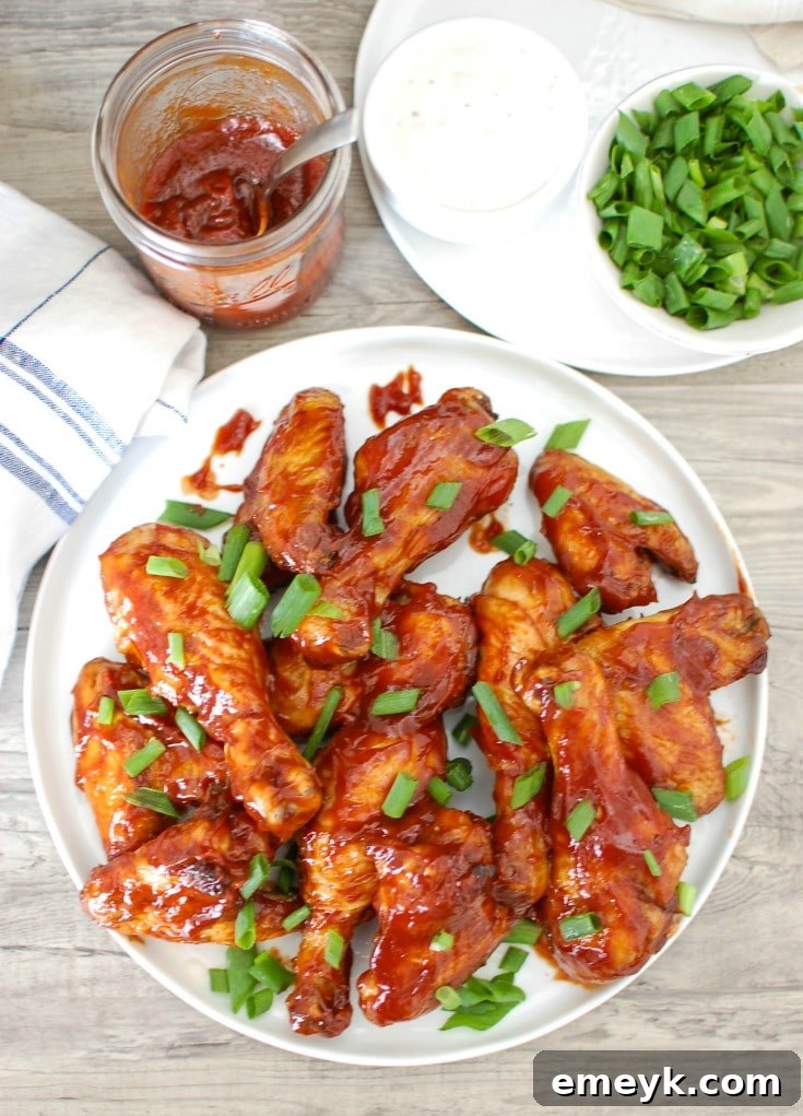 Close-up of baked chicken wings glazed with a rich whiskey barbecue sauce, garnished with fresh herbs, ready to be served